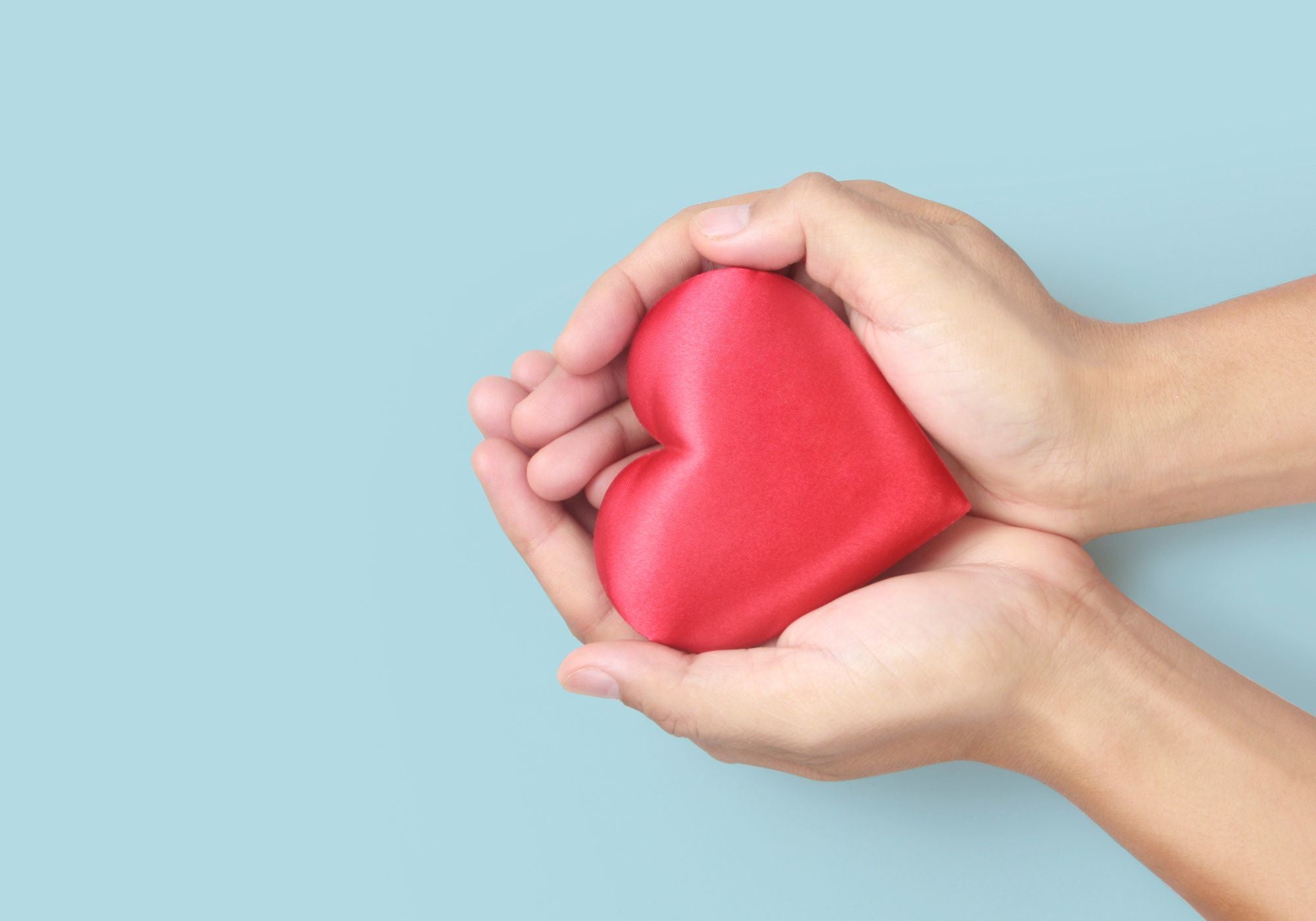 heart in hand on blue background
