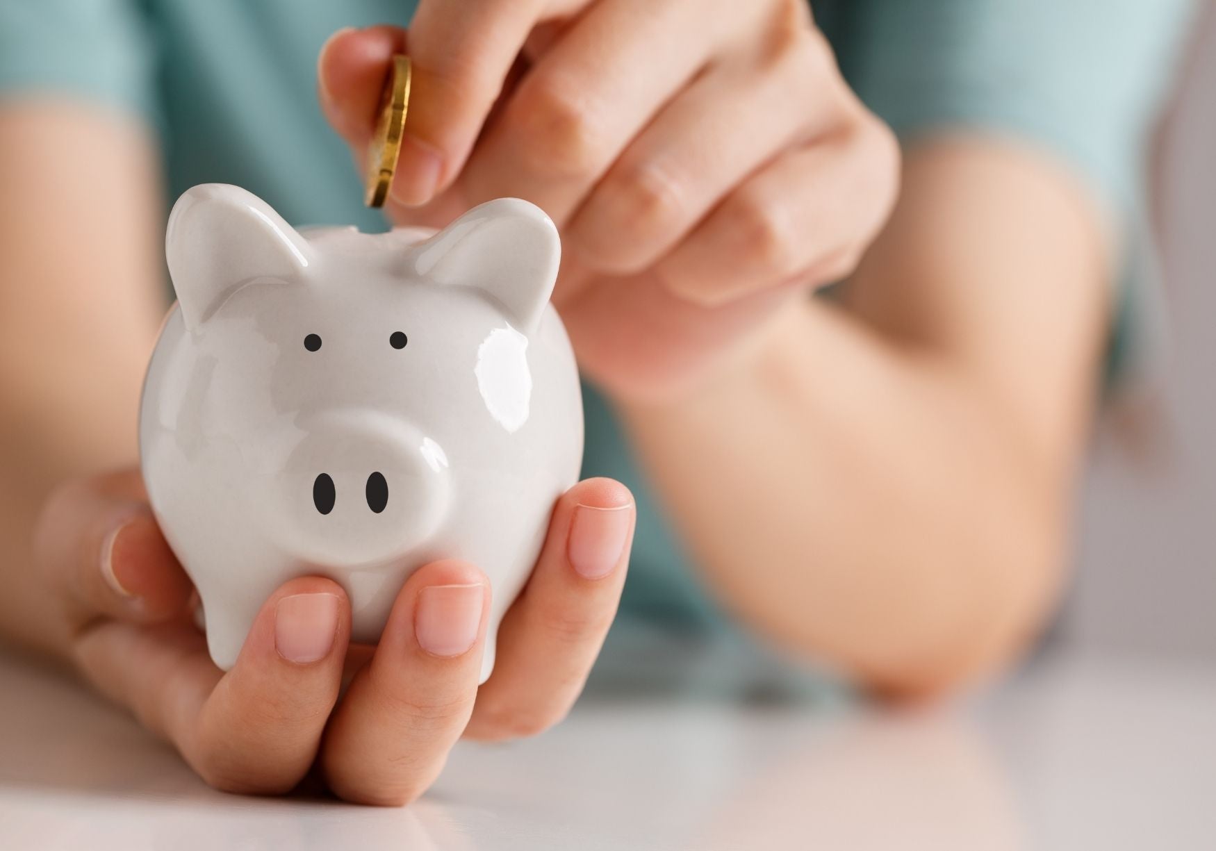 Woman putting money in piggy bank