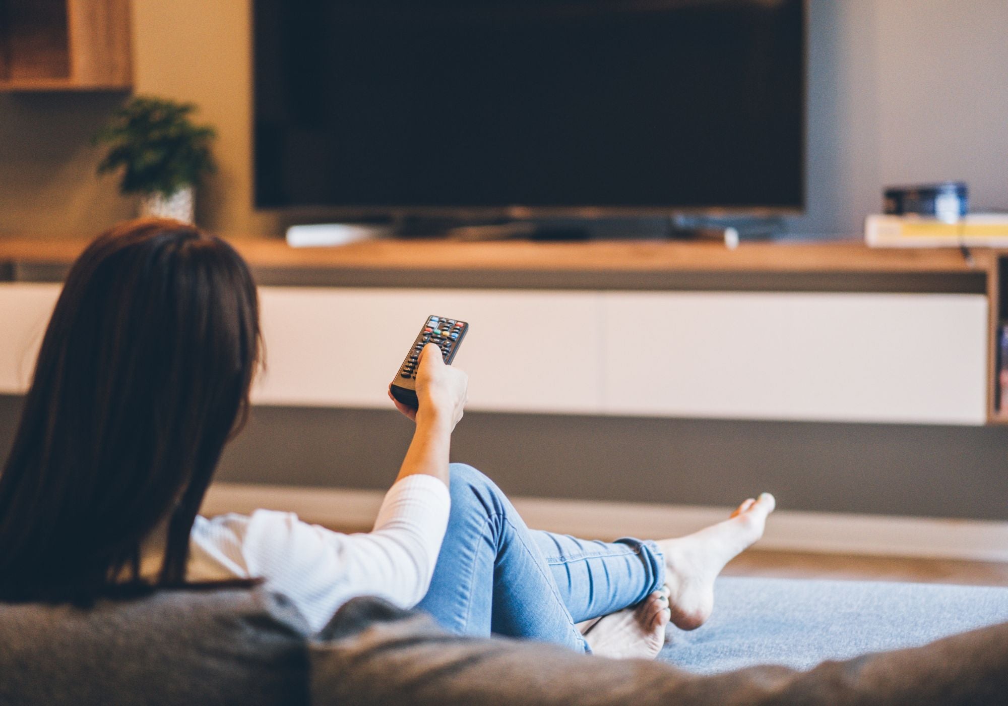 woman watching tv with remote